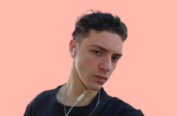 foto do colaborador Murilo, com fundo salmão pastel, um homem branco, de 19 anos, cabelos e olhos castanhos, com um fone de ouvido branco, olhando sério para a câmera com a cabeça levemente inclinada